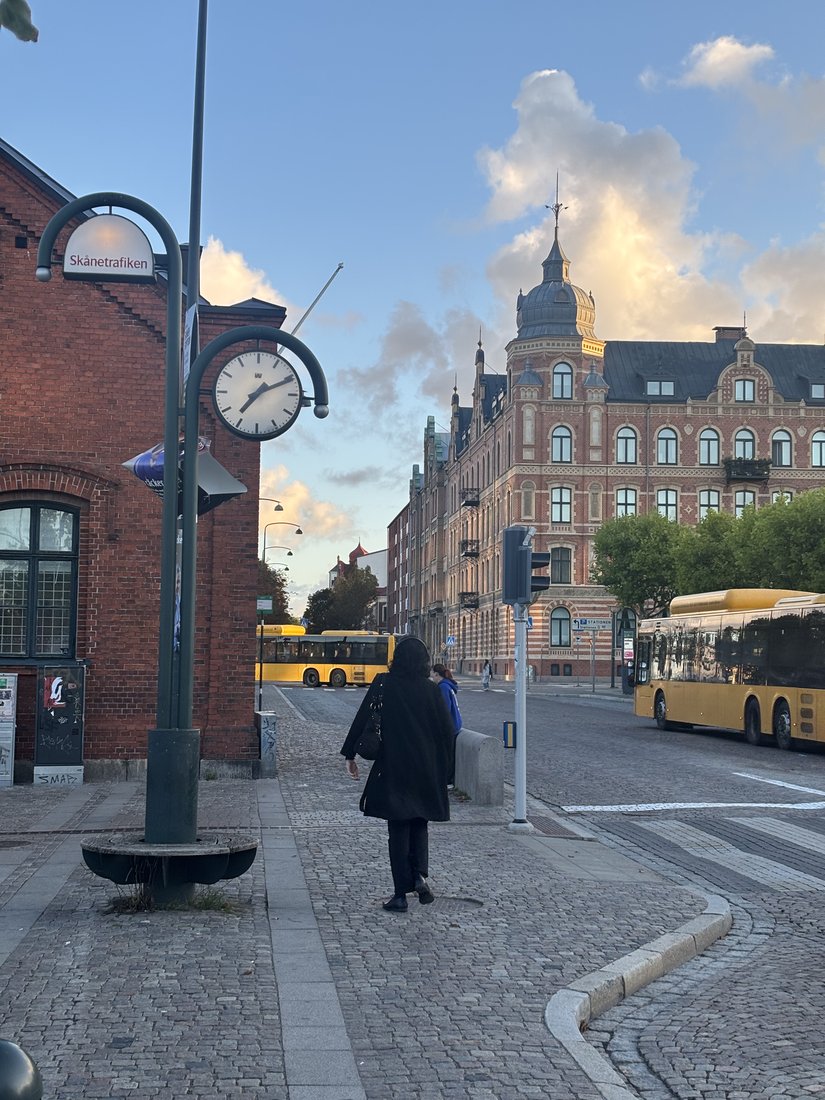 A walk along a brick-lined city street beside an outdoor clock
