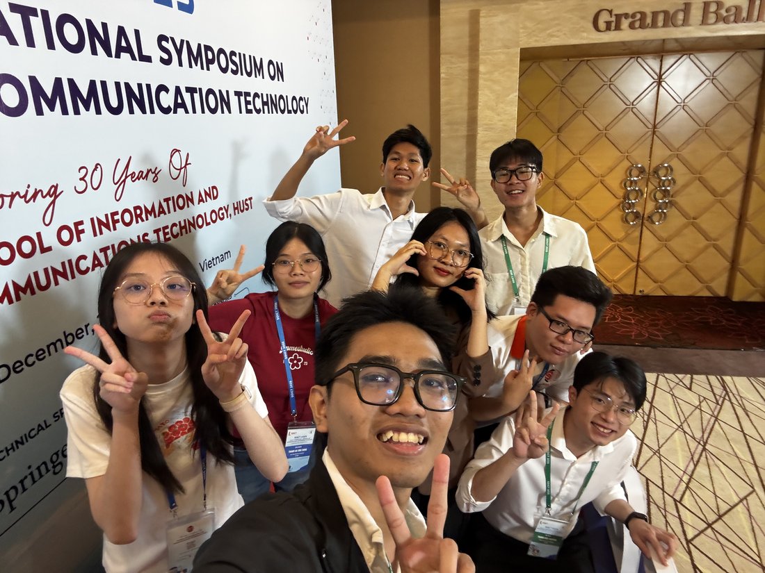 A group photograph with friends in front of the SOICT conference entrance